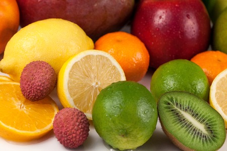 Close-up of assortment of fresh coloured tropical fruits. Water drops on some of fruitsの写真素材