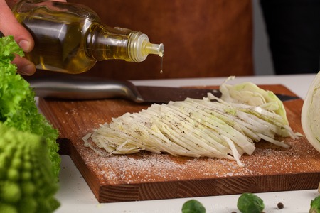 Close-up view oh chefs hand pouring olive oil from a glass bottle. Healthy lifestyle and dieting conceptの写真素材