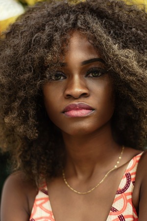 Portrait of attractive young afro american girl with shiny skin and curly hair.の写真素材