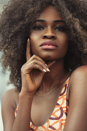 Portrait of pretty afro-american girl with shiny skin, full lips and curly hair.の写真素材