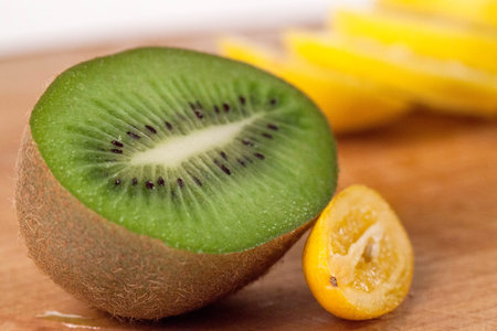 Kiwi and sliced lemon close-up shot. Wooden cutting boardの写真素材