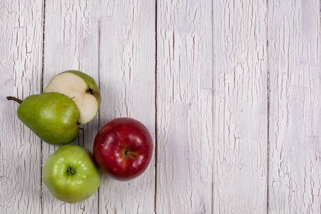 Composition of ripe apples and halved pear on a wooden board. Top viewの写真素材