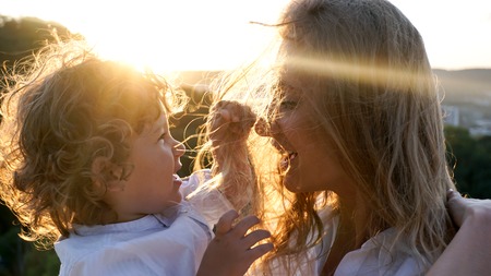 Happy mother and her little child. Child playing with mothers hair,の写真素材