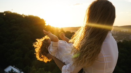 Mother playing with her little son while sunset.の写真素材