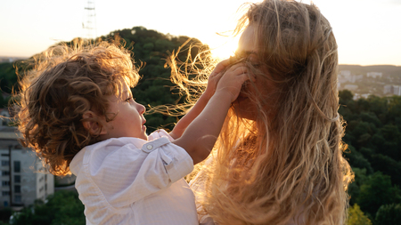 Little son playing with his mothers hair. Beautiful blonde woman.の写真素材