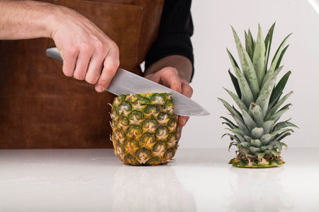 Closeup on woman cutting pineapple
