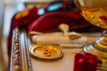 Two golden wedding rings in ceremonial bown on church altar.の写真素材