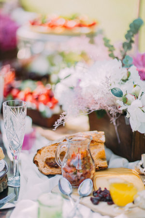 The composition of the wedding table setting. The table is full of beautiful flowers in the wooden...