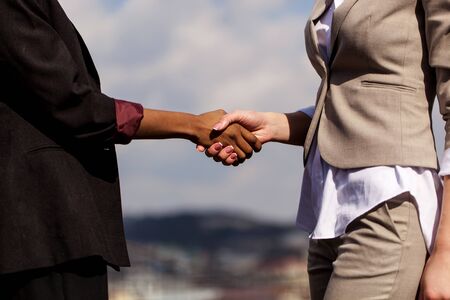Close up shot of shaking hands. Two businesswomen shaking hands with each other after good deal.の写真素材