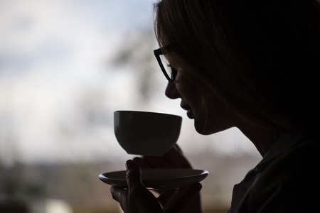 Closeup shot of a woman drinking tea or coffee.の写真素材