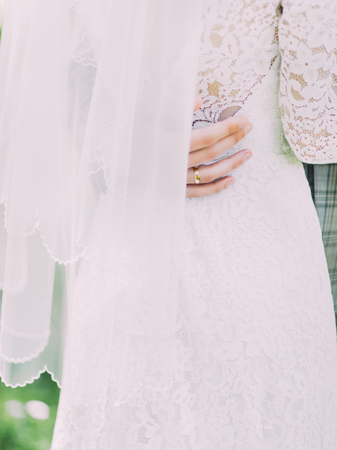 The close-up view of the hand of the groom touching the bride`s back.の写真素材
