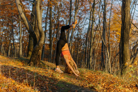 Fit woman athlete doing stretching exercises outdoors in woods. Female sports model exercising...