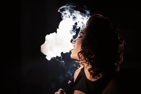 Close-up shot of alluring woman smoking hookah.