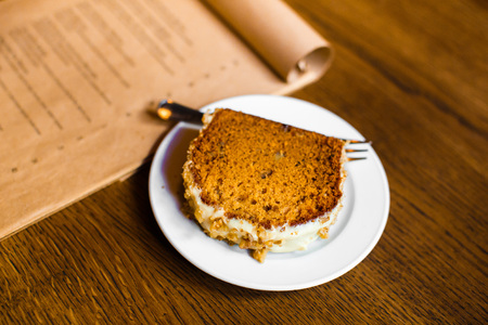 The side photo of the delicious sponge cake decorated with white chocolate and nuts. The table setの写真素材
