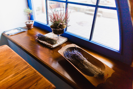 The side photo of the wooden dishes with dried colourful field flowers on the window-sillの写真素材