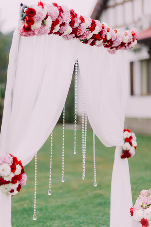 Side view of the wedding arch decorated with colourful flowers and hanging beadsの写真素材