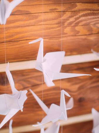 Close-up view of the paper swan hanging on the ceilingの写真素材