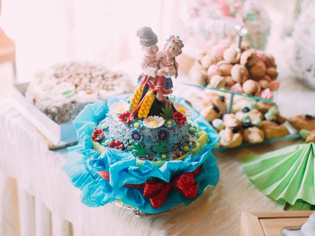 The close-up view of the blue cake decorated with flowers and people dressed in ukrainian clothesの写真素材