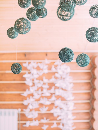 The composition of the black string balls hanging in the front of the white paper swansの写真素材