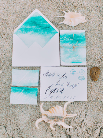 The above view of the composition consisted of the painted letters lying on the sand near the shellsの写真素材