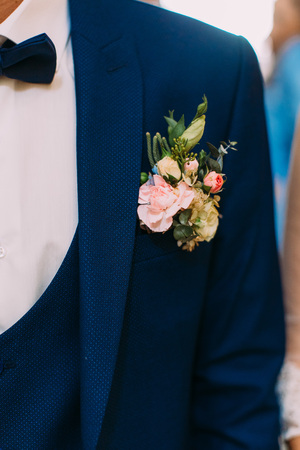 Lovely boutonniere of colourful roses on the jacket of the groomの写真素材
