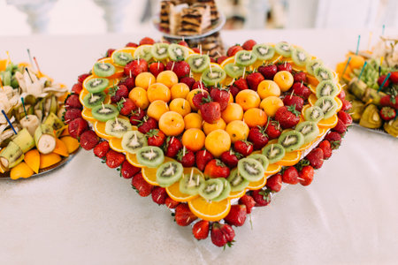 Close-up view of the heat of the strawberries, oranges and kiwi. The wedding table set