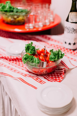 Plate of lettuce and tomatoes on the wedding table setの写真素材