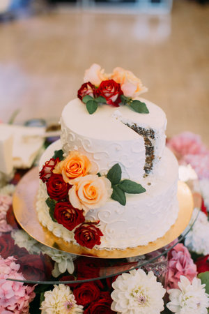 Close-up view of the wedding cake decorated with colourful roses
