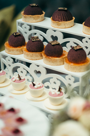 Dessert stand with chocolate cupcakes and cups with jelly and marshmallows for the wedding party. Close-up shot.の写真素材