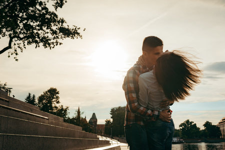 Emotional portrait of the beautiful loving couple hugging in the town street during the sunset. The...