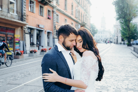 Newlywed couple in love is softly hugging in the town street. Sensual wedding portrait.の写真素材