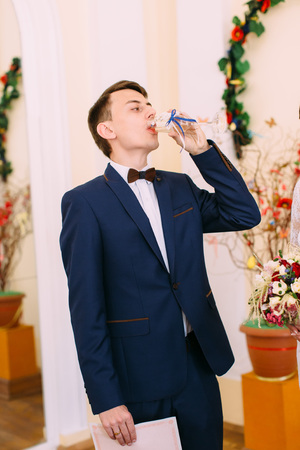 Half-length photo of the groom drinking champagne.の写真素材