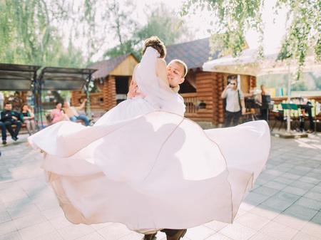 Groom is spinning the lovely bride in the long wedding dress.の写真素材