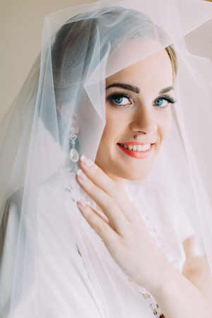 Pretty bride with blue eyes and wedding veil. Close-up portrait.の写真素材