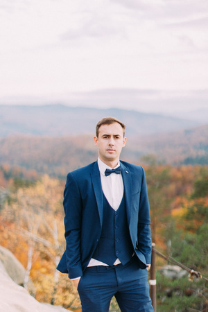 Half-length portrait of the groom at the blurred background of the yellowed forests.の写真素材