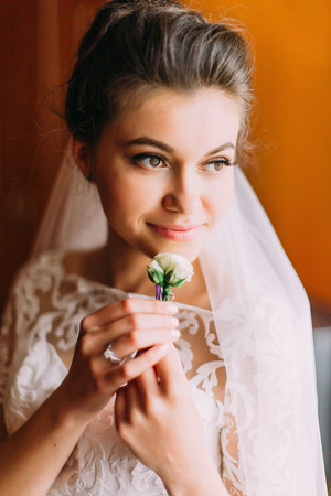 Charming bride with the rose boutonniere looks aside. The close-up portrait.の写真素材