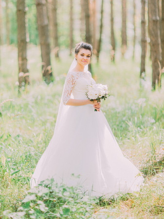 The walk of the wonderful happy bride along the green forest.の写真素材