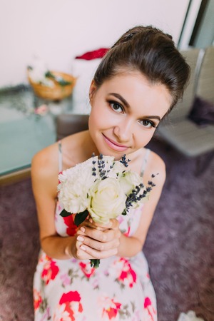 Beauitiful smiling bride with the wedding bouquet of white roses.の写真素材