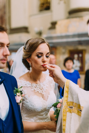 Vertical photo of the bride kissing the wedding ring.の写真素材