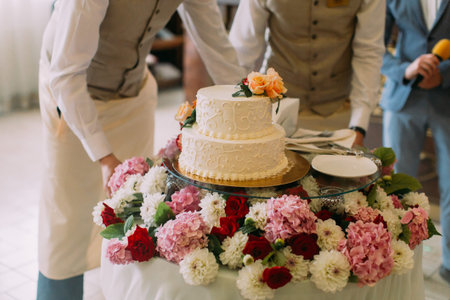 The close-up view of the white wedding cake decorated with colourful flowersの写真素材