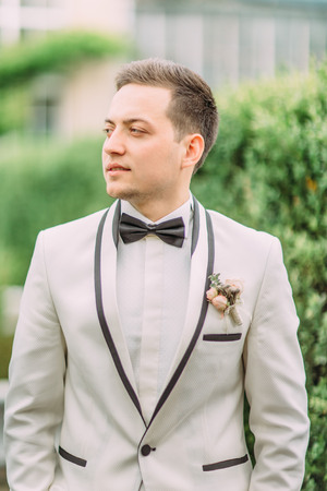 Side view of the groom looking aside. Garden location.の写真素材