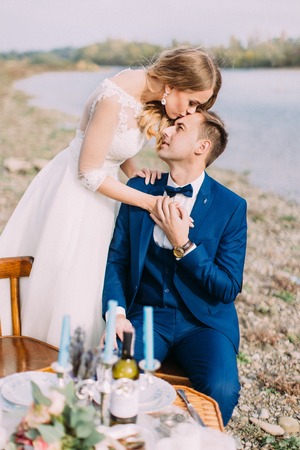 Close-up portrait of the bride kissing the groom in the forehead.の写真素材