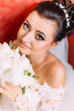Close-up portrait of the bride with wedding bouquet of white roses.の写真素材