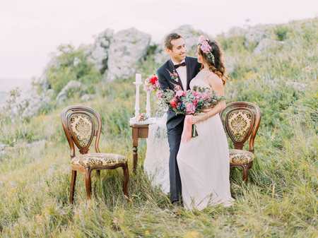 Happy newlyweds are spending time in the mountains. The composition of the wedding table set.の写真素材