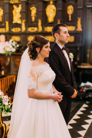 Cheeful newlyweds during the wedding ceremony in the church.の写真素材