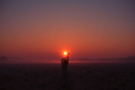 Desert in Egypt. Rock and sunset. Girl in egypt style clothes. Evening, calm orange/purple coloursの写真素材