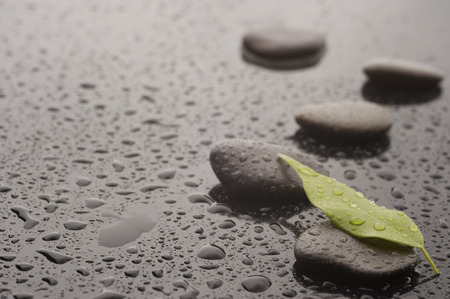 Spa massage stones with leave and water drops, close upの写真素材