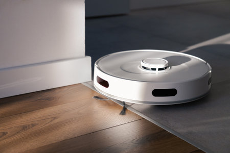 A white robot vacuum cleaner cleans tiles and wooden floors. collects dust and washes the floor. morning in a cozy apartment. automatic management of modern technologies. rays of the sun in the roomの写真素材