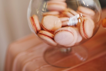 Colorful macarons stand in round transparent weight as part of candy bar sweet tableの写真素材