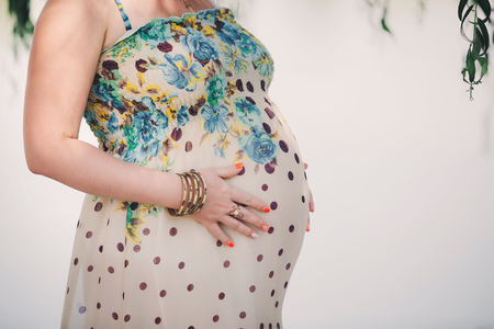 pregnant woman in a beautiful dress. Focus on the abdomen.の写真素材
